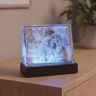 Selbststehendes 2D-Glasbild Querformat mit Paarfoto, blau beleuchtet auf einem Sockel