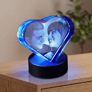 2D-Glasherz mit Fotogravur eines Paares, blau beleuchtet auf dem runden Sockel