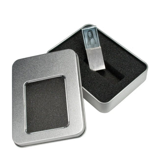 Ein 2D-USB-Stick mit Foto-Gravur von Engravy ist teilweise in eine rechteckige, mit Schaumstoff ausgekleidete Metallbox eingeschoben, deren Deckel links zur Seite gelegt ist.