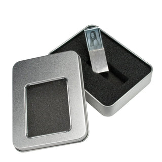 Ein 2D-USB-Stick mit Foto-Gravur von Engravy ist teilweise in eine rechteckige, mit Schaumstoff ausgekleidete Metallbox eingeschoben, deren Deckel links zur Seite gelegt ist.