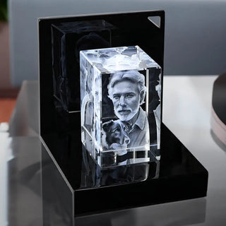 Der Engravy 3D-Glasblock Hochformat aus Kristallglas zeigt das Porträt eines Mannes und seines Hundes. Er ruht auf einem LED-Leuchtsockel, der die Gravur beleuchtet und ihre komplizierten Details mit einem faszinierenden Glanz hervorhebt.