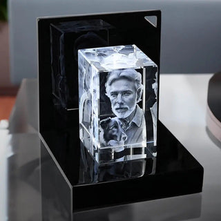 Der Engravy 3D-Glasblock Hochformat aus Kristallglas zeigt das Porträt eines Mannes und seines Hundes. Er ruht auf einem LED-Leuchtsockel, der die Gravur beleuchtet und ihre komplizierten Details mit einem faszinierenden Glanz hervorhebt.