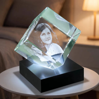 3D-Glaswürfel auf der Ecke stehend, beleuchtet auf dem Leuchtsockel