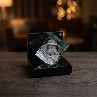 Fotogravur im 3D-Glaswürfel auf dem Leuchtsockel am Abend