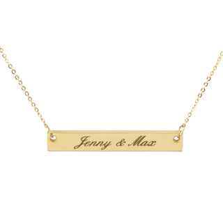 Die Halskette mit Gravur von Engravy ist eine elegante goldene Halskette mit einem rechteckigen Anhänger mit der Gravur „Jenny & Max“, der auf beiden Seiten an einer zarten goldenen Kette befestigt ist.