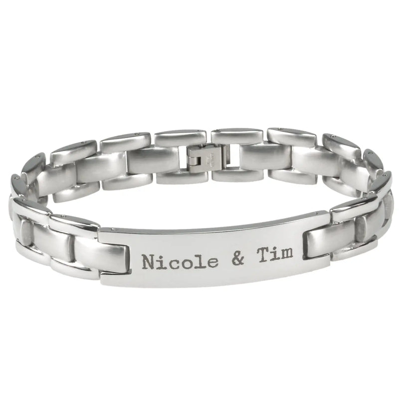 Das Herren-Edelstahl-Armband mit Gravur von Engravy verfügt über ein silbernes Metallgliederdesign mit einer Mittelplatte mit der Gravur „Nicole & Tim“. Es hat einen sichtbaren Verschluss auf der Rückseite und eine polierte, reflektierende Oberfläche und verkörpert ein zeitloses Design.