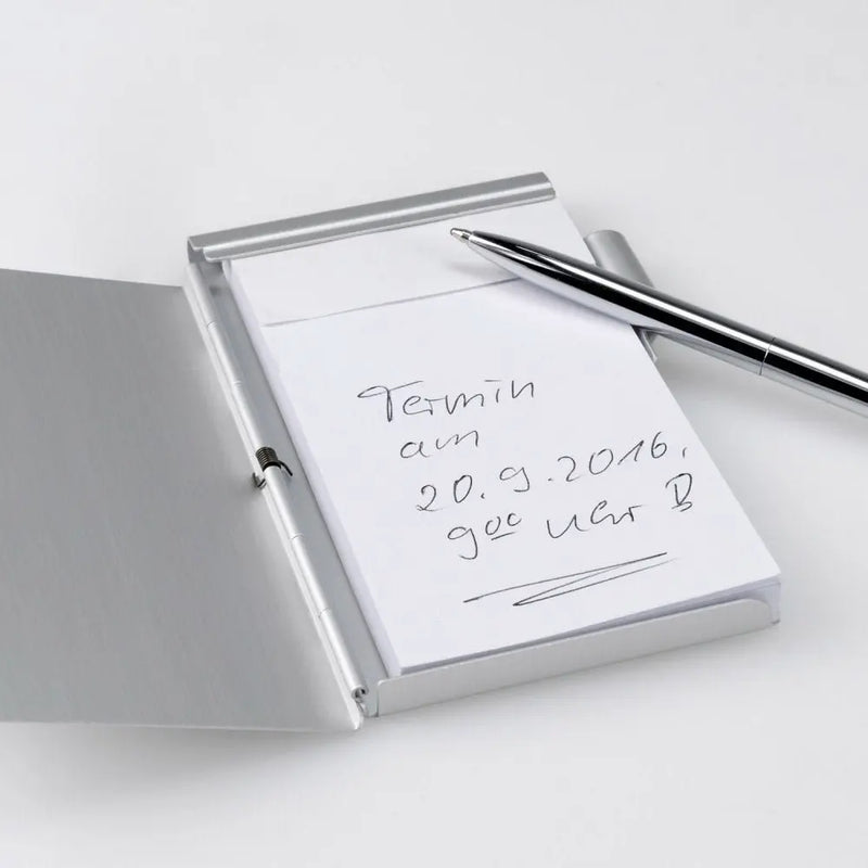 Ein Engravy-Notizblock mit Gravur von Notizblock mit Gravur – Praktisch & elegant mit der Notiz „Termin am 20.9.2016, ggf. Unit B“ und einem silbernen Stift oben in einem eleganten Aluminiumetui.