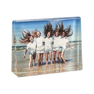 Das personalisierbare Foto in Glas – Querformat von Engravy zeigt fünf Menschen, die im seichten Strandwasser stehen. Sie tragen weiße Hemden und im Wind flatternde Shorts, haben verschränkte Arme und lächeln unter einem klaren blauen Himmel und fangen einen perfekten Moment ein.