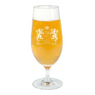 Ein hohes, klares Engravy Pilsglas mit Gravur – 330 ml ist mit schaumigem, goldenem Bier gefüllt und verfügt über eine eingravierte Krone, zwei Löwen und „38 Jahre Andreas“, was es zum perfekten Geschenk für Bierliebhaber macht. Das Glas ruht elegant auf einem weißen Hintergrund.