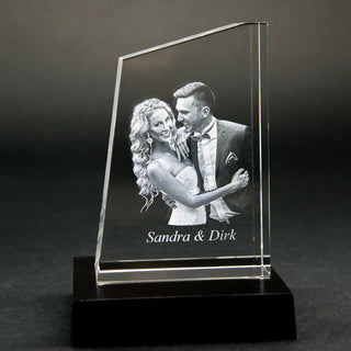 Die Engravy Premium 3D-Glasgravur – The Tower zeigt eine 3D-Gravur eines lächelnden Paares in formeller Kleidung mit „Sandra & Dirk“. Dieses einzigartige Design wird elegant auf einem schwarzen Untergrund dargestellt.