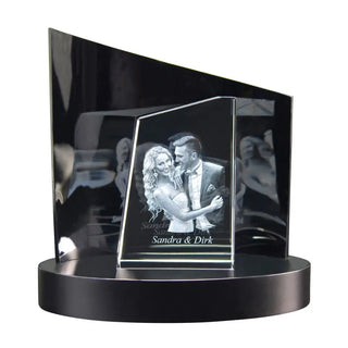 Eine Premium-3D-Glasgravur von Engravy, „The Tower“, zeigt ein lächelndes Paar, das auf einem schwarzen runden Sockel mit einem eckigen schwarzen Hintergrund tanzt. Die Namen „Sandra & Dirk“ sind darunter eingraviert und werden durch exquisites Design für besondere Momente zum Leben erweckt.