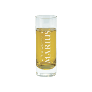 Ein hohes, klares Glas mit goldener Flüssigkeit zeigt das Etikett „Engravy“. Dieses atemberaubende Stück aus dem Set „Schnapsgläser mit Gravur“ ist eine perfekte personalisierte Geschenkidee für jeden Anlass und steht elegant vor einem schlichten weißen Hintergrund.