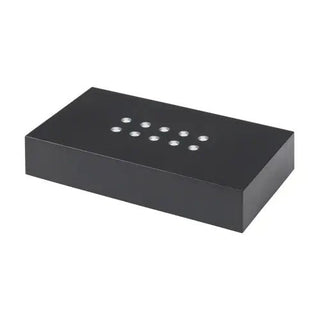 Das Engravy Sockel Scheibe selbstehend Batteriefach ist eine elegante, schwarze rechteckige Box mit glatter Oberfläche und Lasergravur. Auf der Oberseite sind metallische Kreisausschnitte in zwei Reihen angeordnet, die einen eleganten Kontrast zum schlichten weißen Hintergrund bilden.