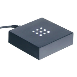 Der Engravy Sockel Scheibe selbstehend Hochformat ist ein schwarzer quadratischer LED-Ständer mit weißen Lichtern oben, ideal für die Präsentation von Glasblöcken. Ein Netzkabel auf der Rückseite sorgt für ein nahtloses Lichterlebnis.