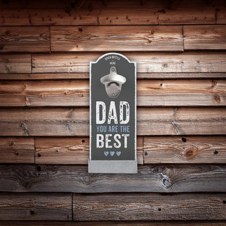 An einer Holzwand hängt ein Wand-Flaschenöffner mit Digitaldruck von Engravy mit der Aufschrift „PAPA, DU BIST DER BESTE“ im Vintage-Stil. Er verfügt über einen angebrachten Metallöffner mit einem Pfeil mit der Aufschrift „FLASCHE HIER ÖFFNEN“ und bietet eine einfache Wandmontage für eine einfache Aufstellung.