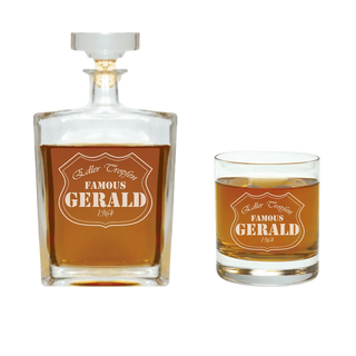 Das Engravy Whisky-Geschenkset mit Gravur besteht aus einer Glaskaraffe und einem Whiskybecher, gefüllt mit bernsteinfarbener Flüssigkeit und elegant arrangiert in einer luxuriösen Geschenkbox. Das Etikett „Famous Gerald 1964“ ziert das Set und macht es zum perfekten Geschenk.