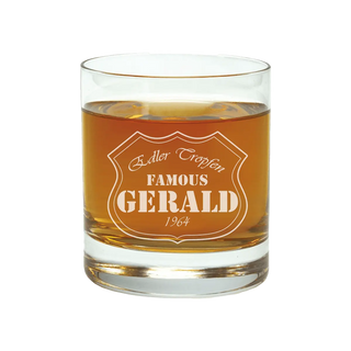 Ein personalisiertes 400 ml Whiskyglas von Engravy, gefüllt mit bernsteinfarbener Flüssigkeit und mit der Aufschrift „Edler Tropfen FAMOUS GERALD 1964“ macht es zu einem idealen Geschenk.