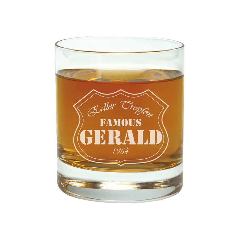 Ein personalisiertes 400 ml Whiskyglas von Engravy, gefüllt mit bernsteinfarbener Flüssigkeit und mit der Aufschrift „Edler Tropfen FAMOUS GERALD 1964“ macht es zu einem idealen Geschenk.